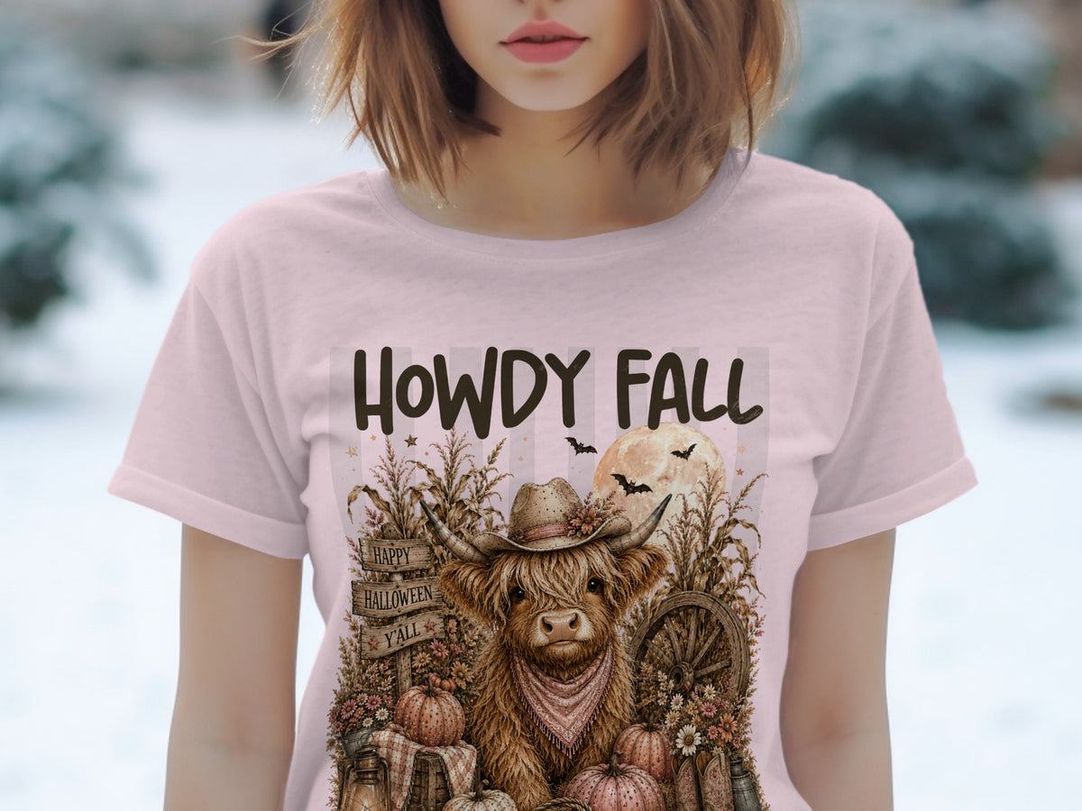T-shirt graphic: Highland cow in cowboy hat, pumpkins, and "HOWDY FALL" text.