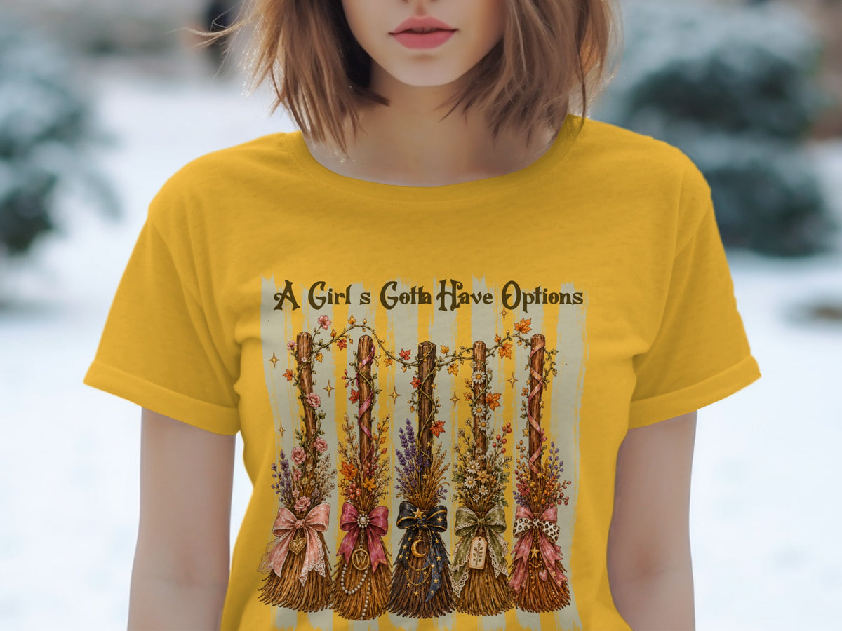Yellow t-shirt with graphic of five decorated brooms and text "A Girl's Gotta Have Options".