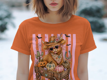 Fuzzy highland cow in cowboy hat with heart sunglasses in a wagon full of pumpkins.