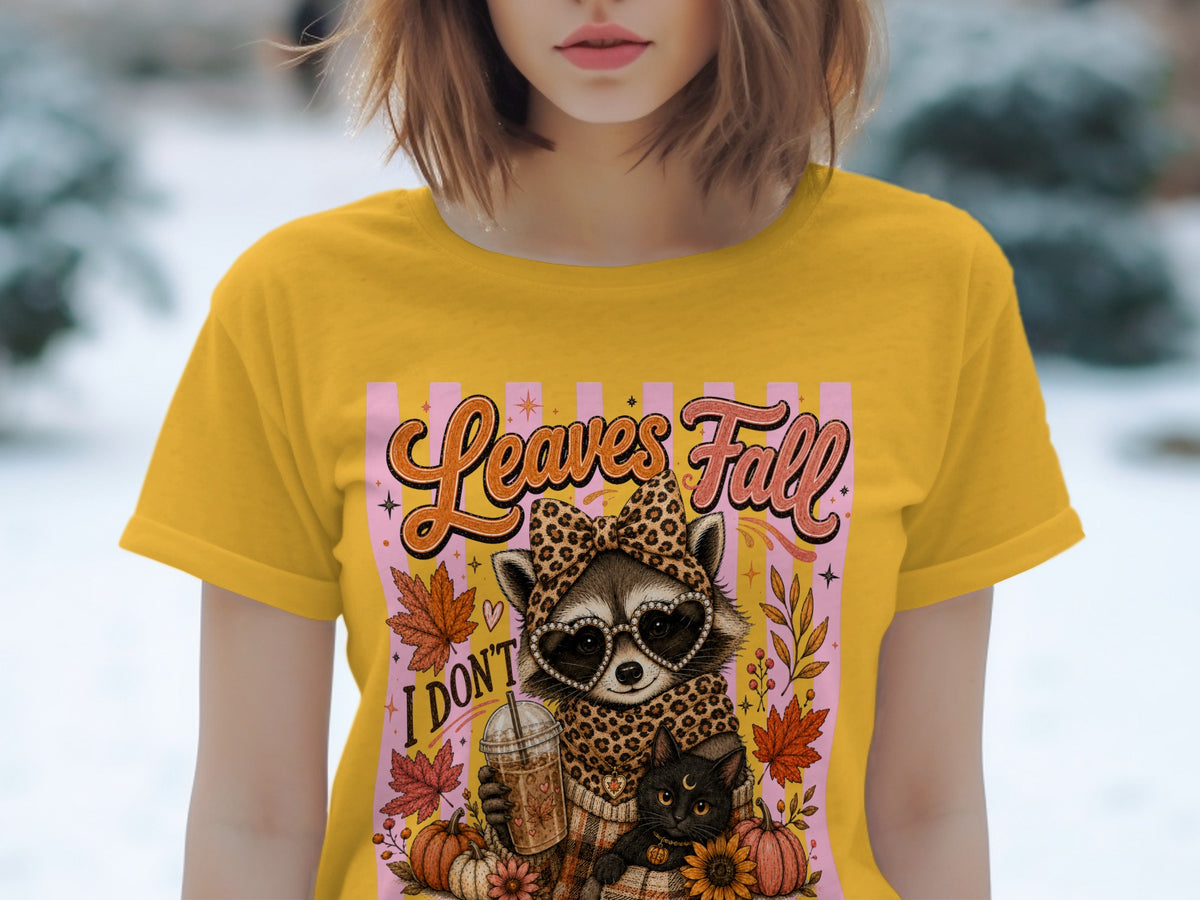 Yellow t-shirt with graphic of raccoon, black cat, coffee, and pumpkins.