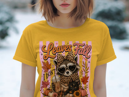 Yellow t-shirt with graphic of raccoon, black cat, coffee, and pumpkins.