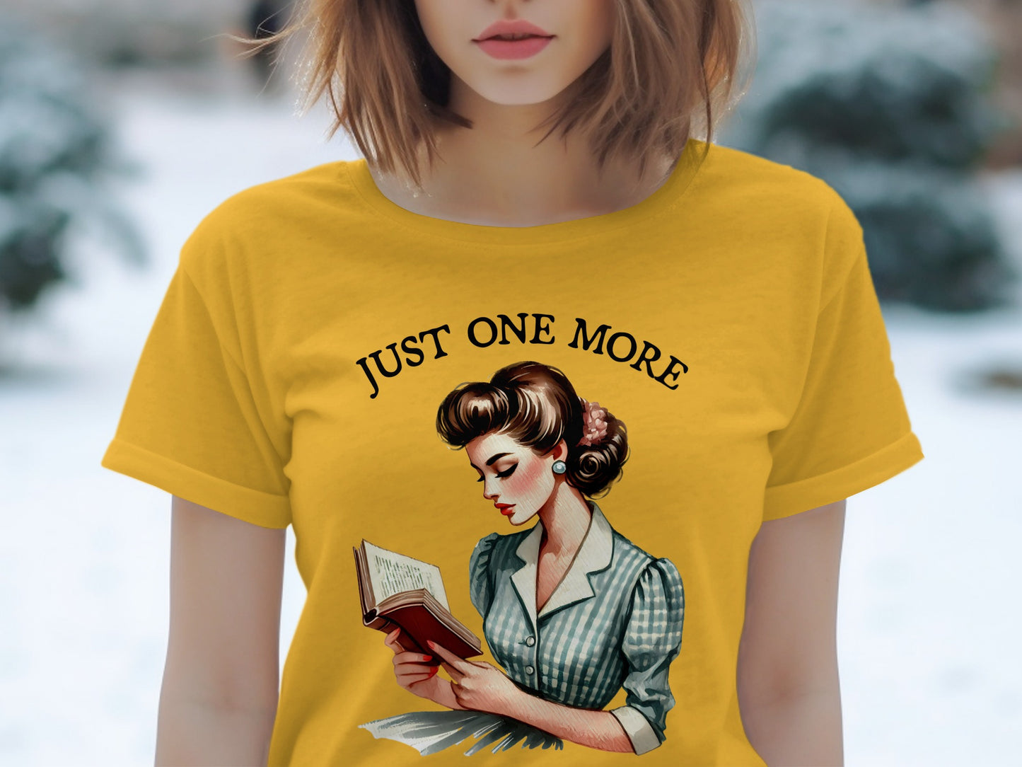 Yellow t-shirt with a vintage woman reading and the text "JUST ONE MORE".