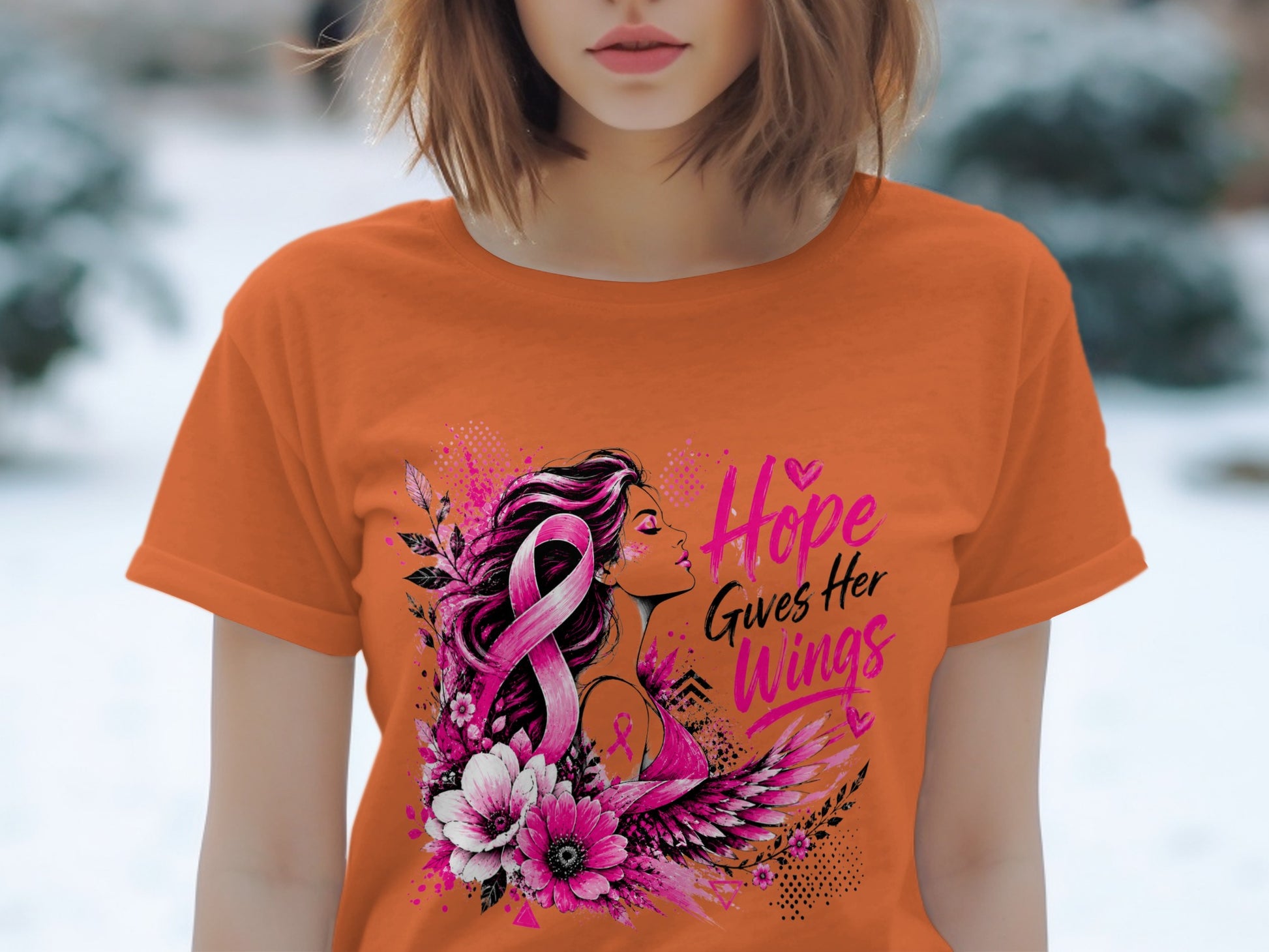 Orange t-shirt with pink breast cancer ribbon, woman, flowers, wings, and text.