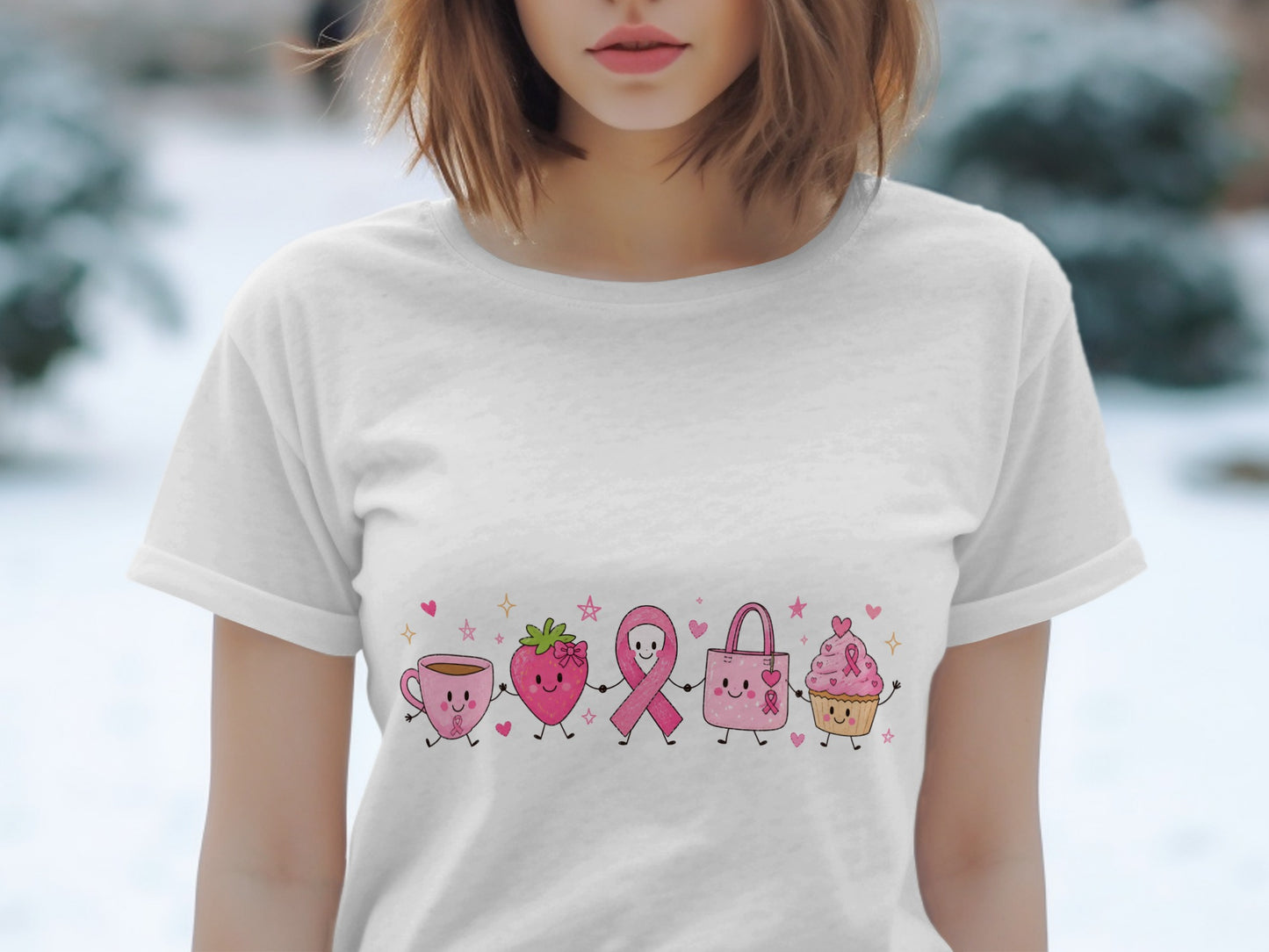 White t-shirt with cartoon pink breast cancer awareness ribbon, strawberry, tote bag, and cupcake.