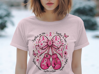 Pink t-shirt with a graphic of boxing gloves, bows, and butterflies with breast cancer ribbons.