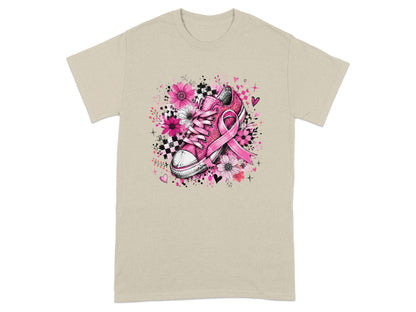Pink sneaker with floral design and breast cancer ribbon on tan t-shirt.