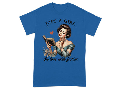 Blue t-shirt with "JUST A GIRL" and woman reading a book, "in love with fiction."