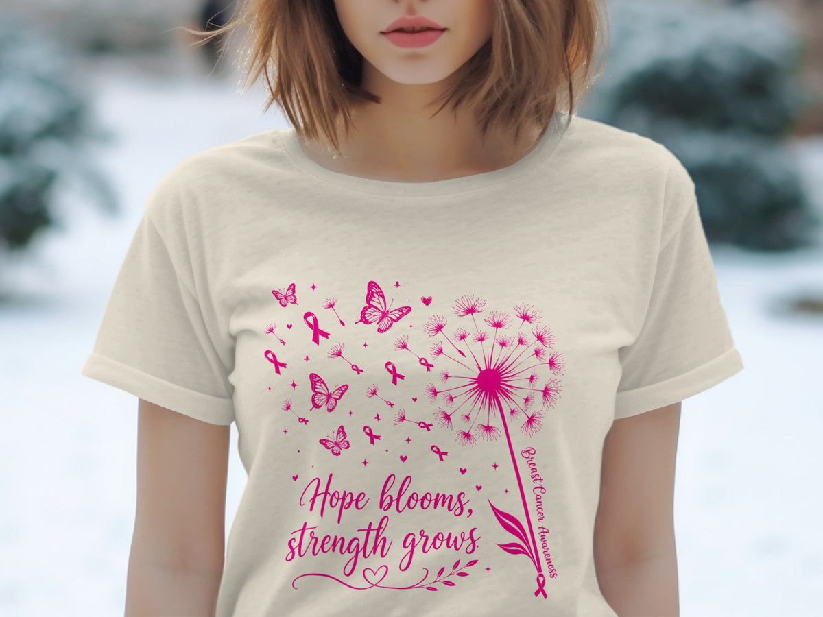 Cream t-shirt with pink dandelion, butterflies, ribbons, and text: "Hope blooms, strength grows".