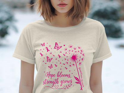 Cream t-shirt with pink dandelion, butterflies, ribbons, and text: "Hope blooms, strength grows".