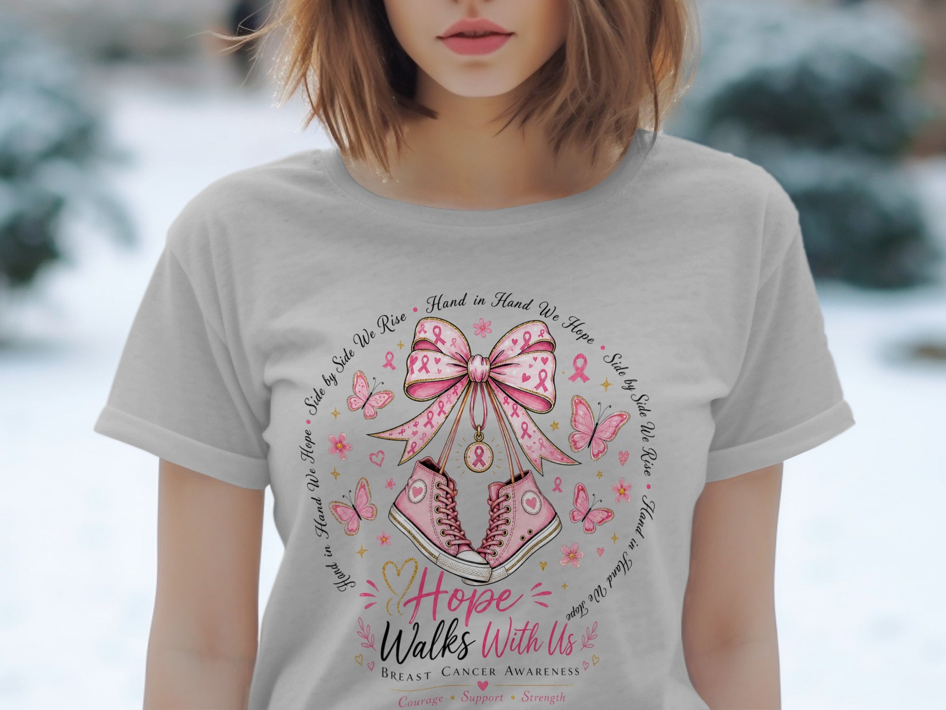 Light gray t-shirt with pink breast cancer awareness graphic featuring sneakers, ribbon, and butterflies.