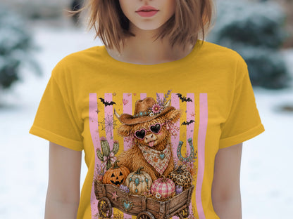 Yellow t-shirt with a Highland cow graphic wearing a cowboy hat and heart sunglasses.