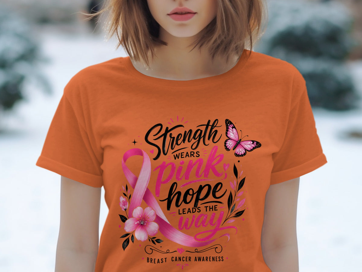 Orange t-shirt with pink ribbon, butterfly, flowers, and text for breast cancer awareness.