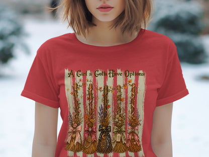 Red t-shirt with "A Girl's Gotta Have Options" and five decorative brooms.