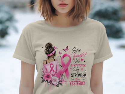 T-shirt with pink ribbon, flowers, and text "She fought She overcame She is STRONGER than YESTERDAY".