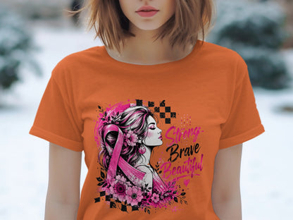 Orange t-shirt with graphic of woman, pink ribbon, flowers, and text "Strong Brave Beautiful".