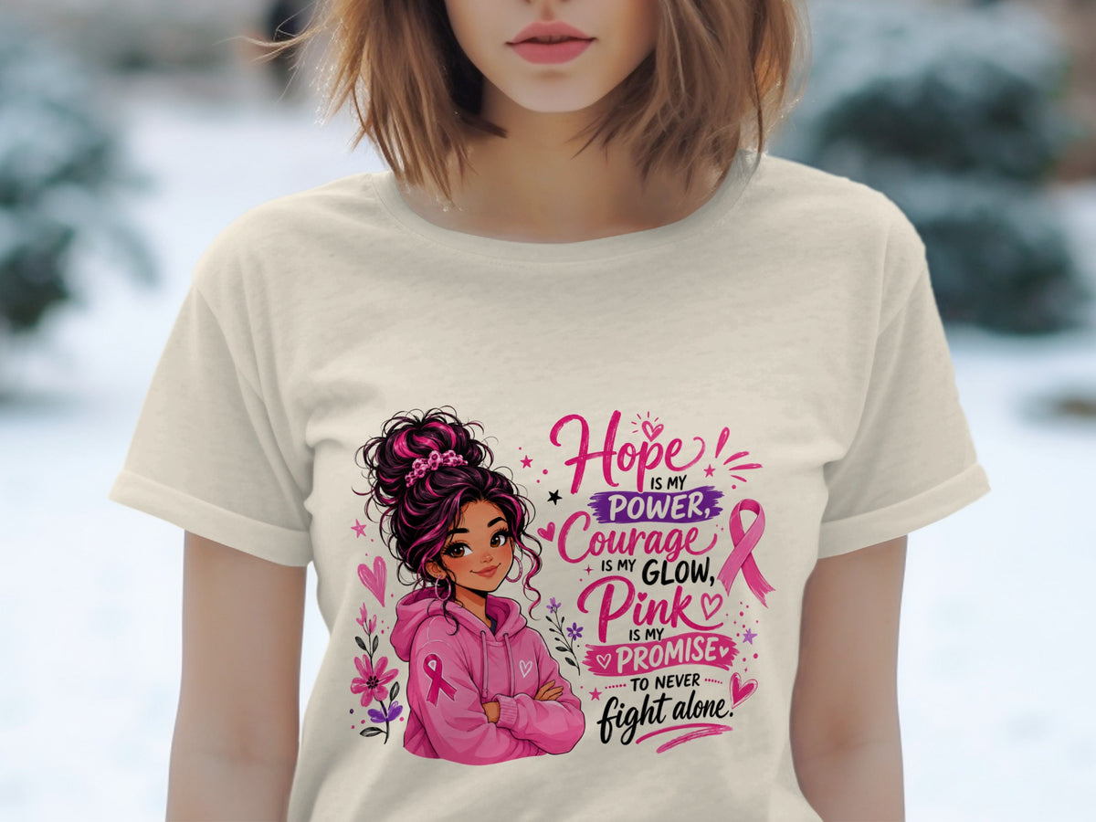 Woman in cream t-shirt with pink graphic: Hope is my power, Courage is my glow, Pink is my promise to never fight alone.