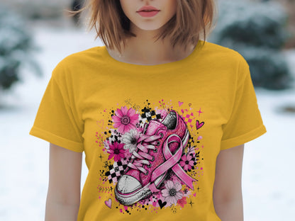 Yellow t-shirt with a pink glitter shoe, pink ribbon, and floral design.