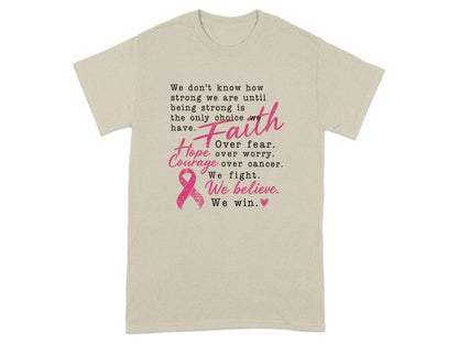 Light tan t-shirt with text about strength, faith, hope, and courage, featuring a pink ribbon.