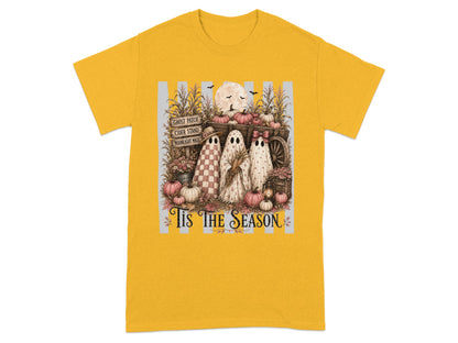 Three ghosts stand by a wagon with pumpkins, corn, and signs. 'Tis the Season.