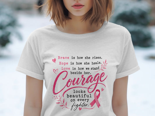 White t-shirt with pink text: "Brave is how she rises. Hope is how she heals. Love is how we stand beside her. Courage looks beautiful on every fighter."
