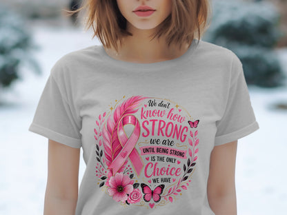 Light grey t-shirt with breast cancer ribbon, feathers, flowers, butterflies, and text.