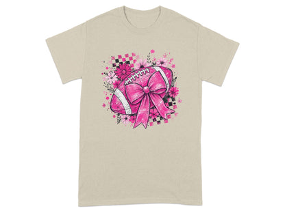 T-shirt with a pink football, bow, flowers, and checkered pattern graphic.