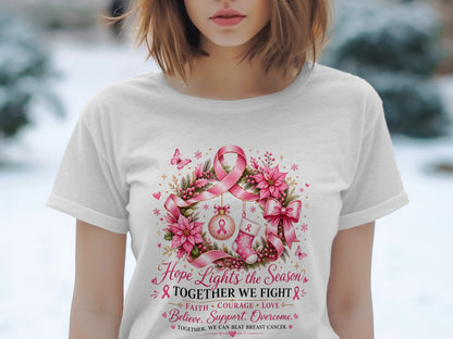 White t-shirt with a wreath graphic, pink ribbons, and text about fighting breast cancer.