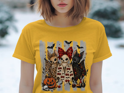 Three cute bats with Halloween decorations on a yellow t-shirt.