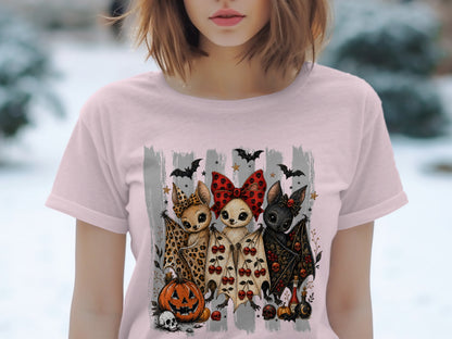 Three cartoon bats with Halloween-themed outfits and accessories, next to pumpkins and skulls.