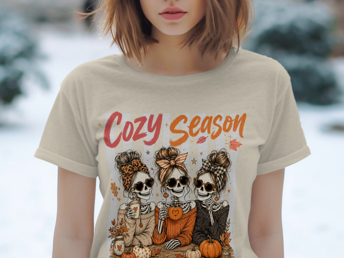 Three skeletons in sweaters and sunglasses, with text "Cozy Season" and pumpkins.