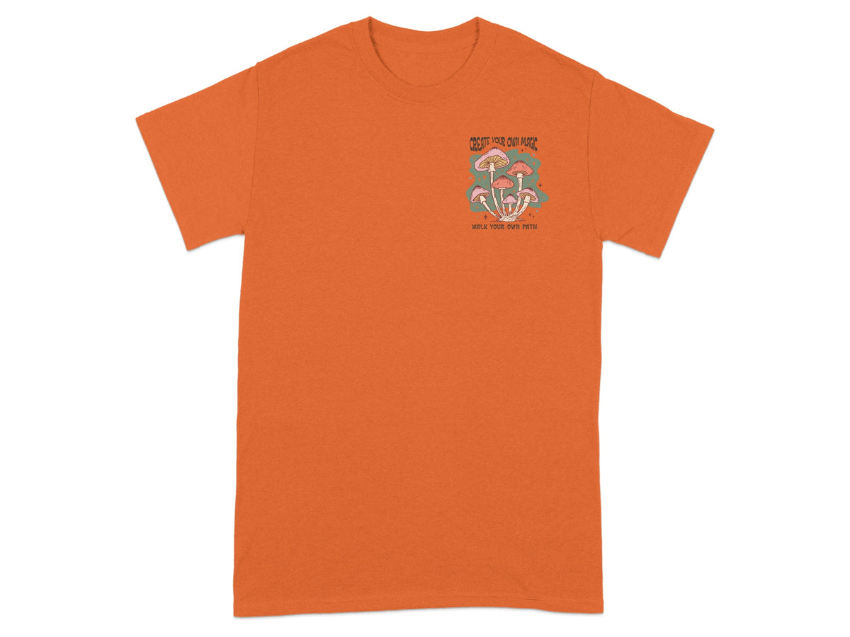 Orange t-shirt with "CREATE YOUR OWN MAGIC WALK YOUR OWN PATH" text and mushroom graphic.