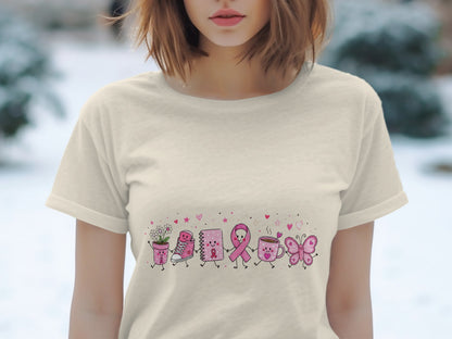 Pink cartoon characters including a flower pot, shoe, notebook, ribbon, mug, and butterfly on a light t-shirt.