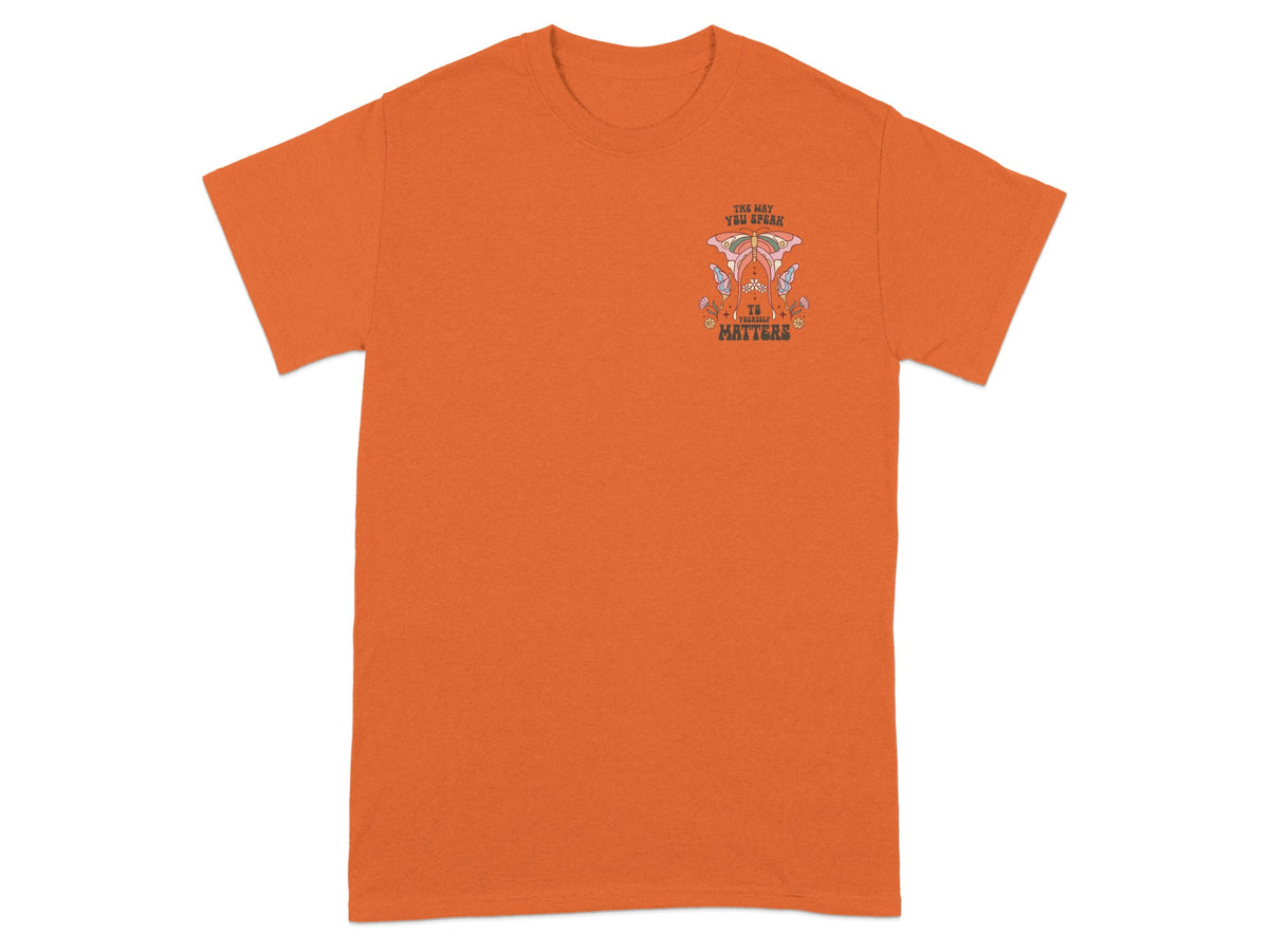 Orange t-shirt with "The way you speak to yourself matters" text and graphic.