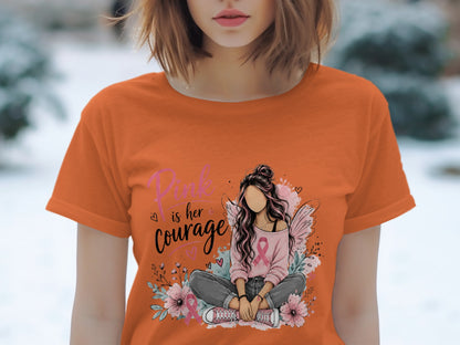 Orange t-shirt with graphic "Pink is her courage" and a seated girl with wings.