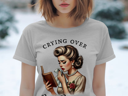 Gray t-shirt with "Crying Over" text and illustration of a crying woman holding a book.