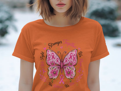 Orange t-shirt with butterfly design featuring pink ribbons and the words "Stronger Together", "We Fight", "We Hope", and "We Believe We Win".