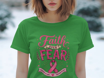 Green t-shirt with pink text that reads "Faith Over Fear" and a pink ribbon.