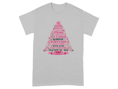 Grey t-shirt with a pink Christmas tree graphic featuring words like Hope, Warrior, Survivor, and Merry & Strong.