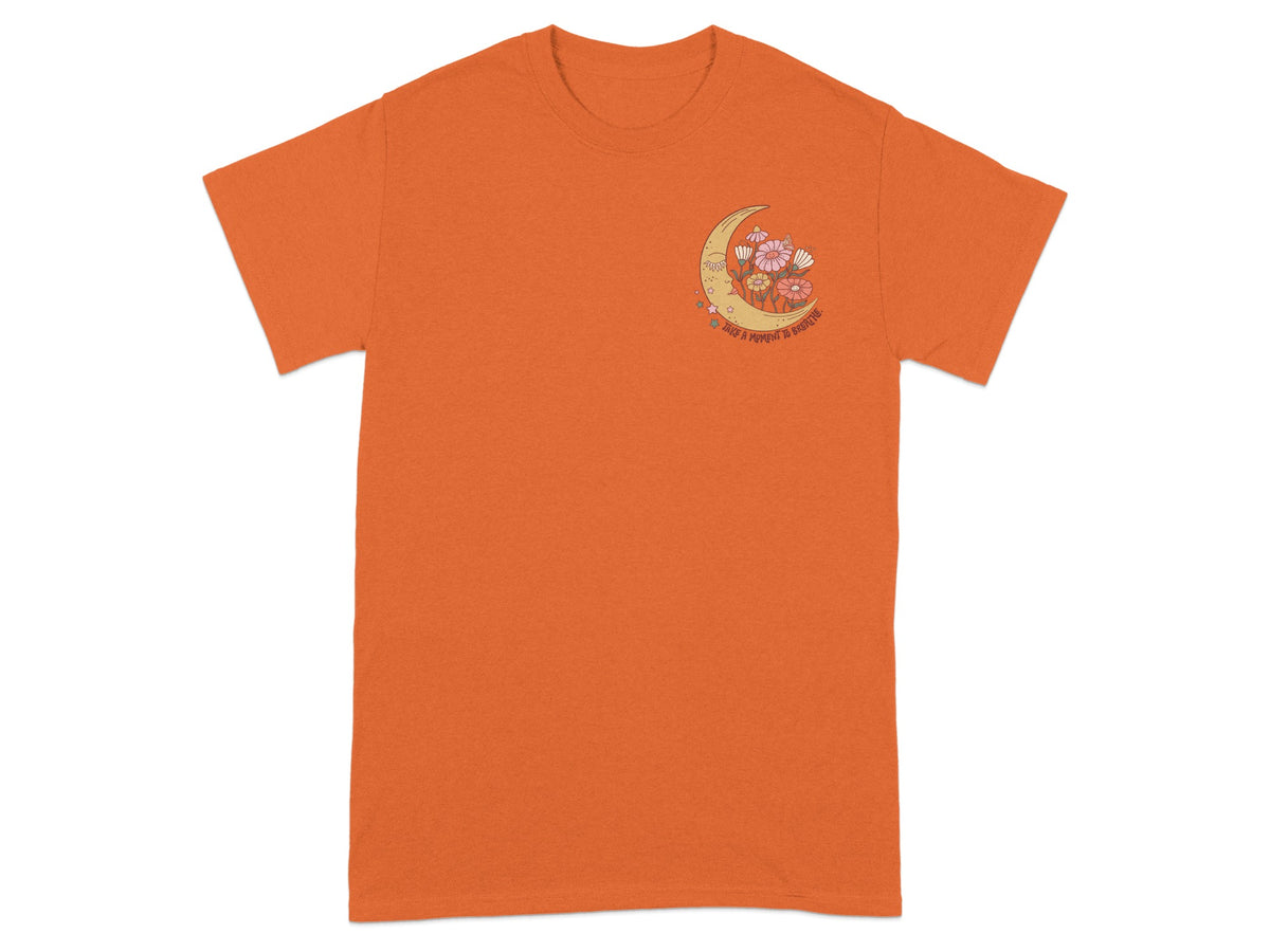 Orange t-shirt with a crescent moon, flowers, and text reading "TAKE A MOMENT TO BREATHE".