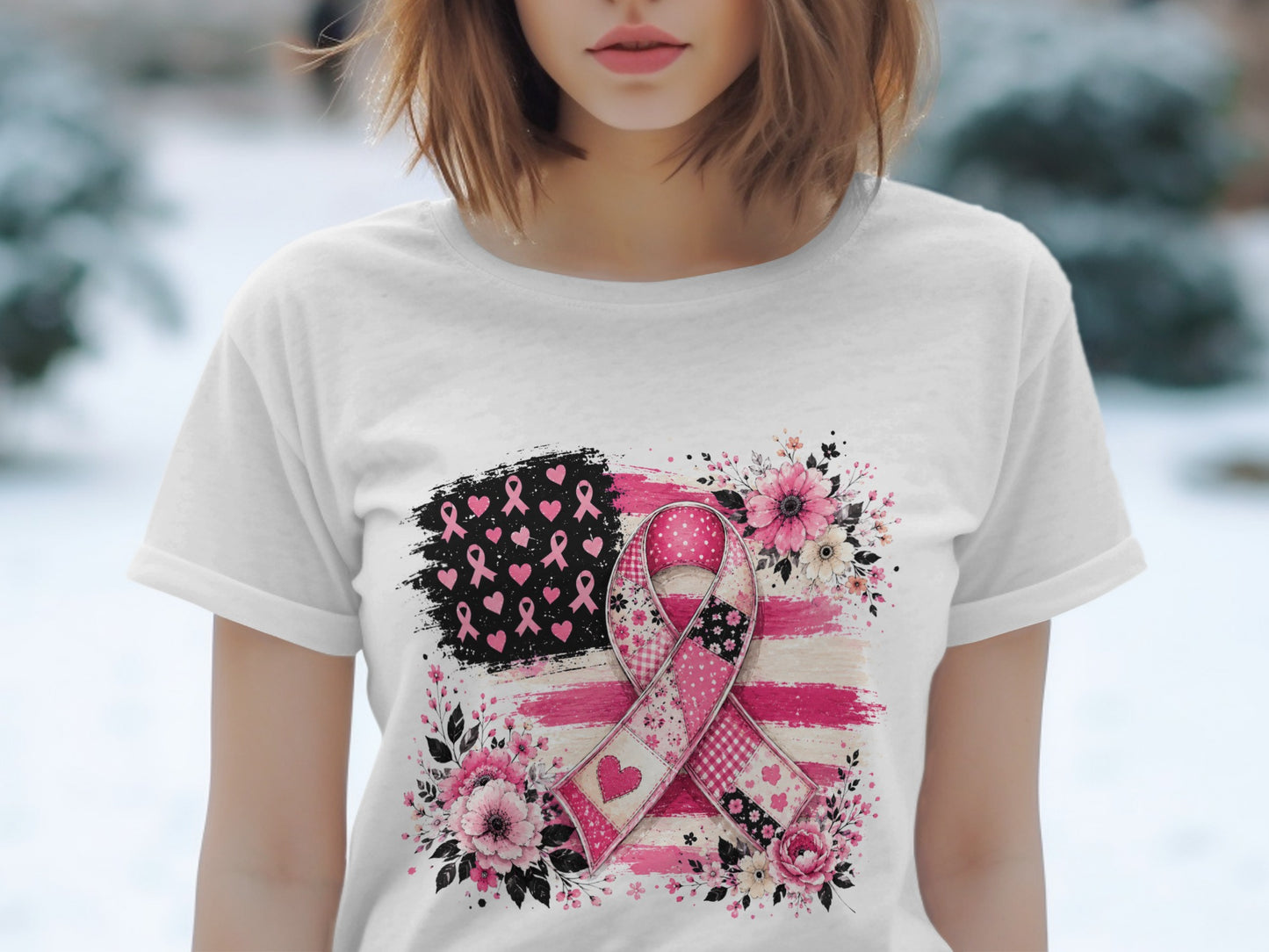 Pink ribbon over distressed American flag with floral accents on a white t-shirt.