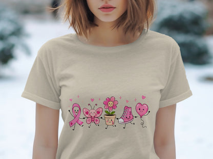 Tan t-shirt with cartoon pink ribbon, butterfly, flower, sneaker, and heart balloon.