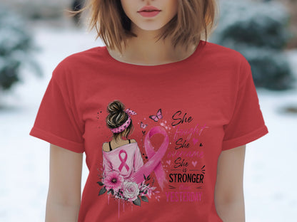 Red t-shirt with graphic of woman, pink ribbon, and text "She is stronger than yesterday."