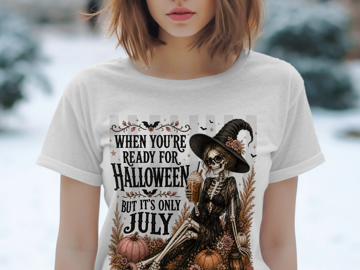 White t-shirt with skeleton witch, pumpkins, and text "When You're Ready for Halloween But It's Only July".