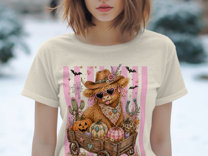 Cowboy Highland cow in a wagon with pumpkins, bats, and pink stripes.