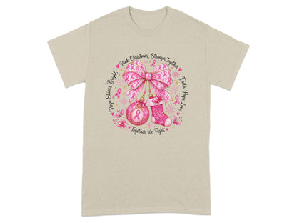 T-shirt with circular graphic featuring pink ribbons, bow, ornament, stocking, and text.