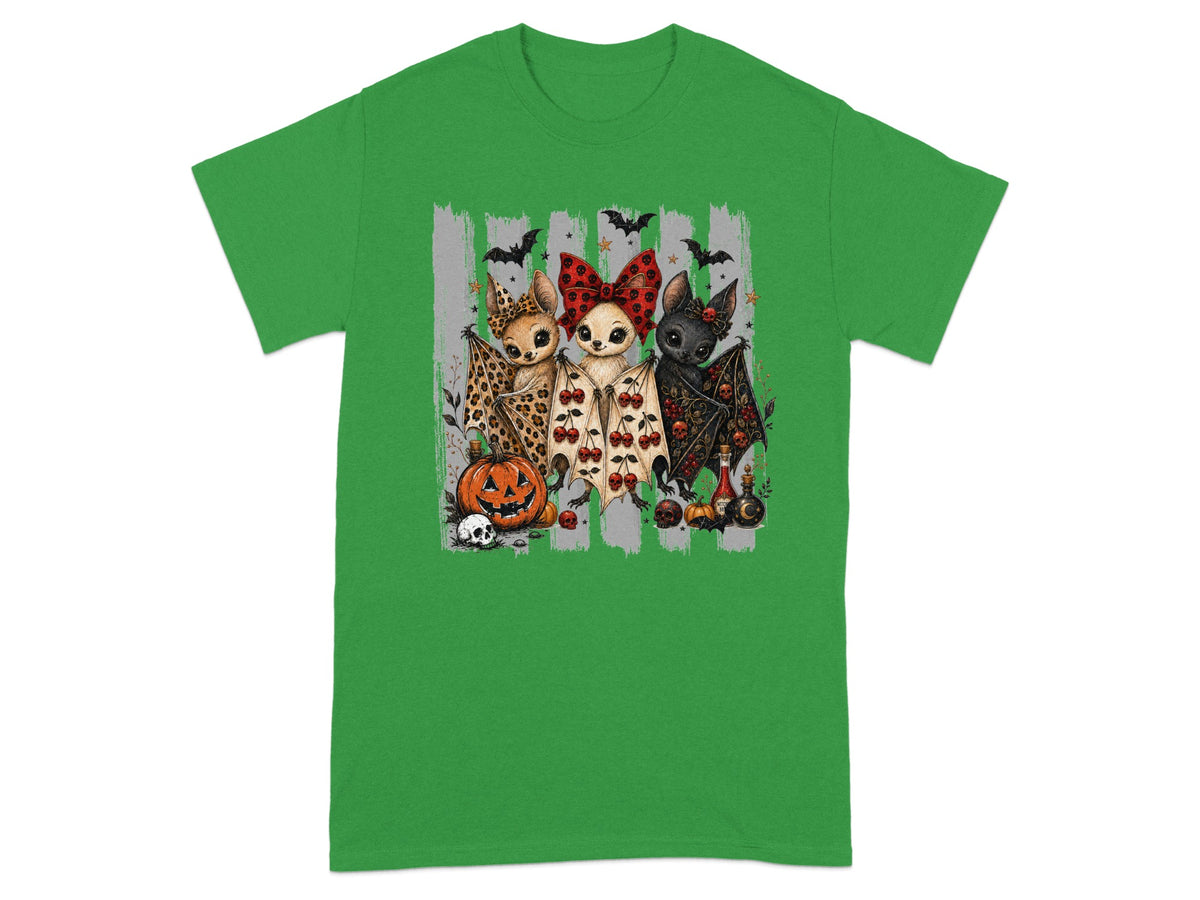 Three cartoon bats with Halloween themes, a pumpkin, and skulls on a green t-shirt.