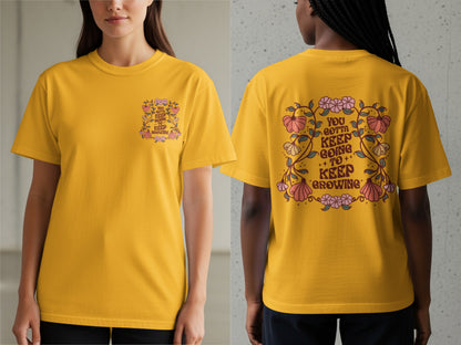 Yellow t-shirt with a floral design and text "You gotta keep going to keep growing".