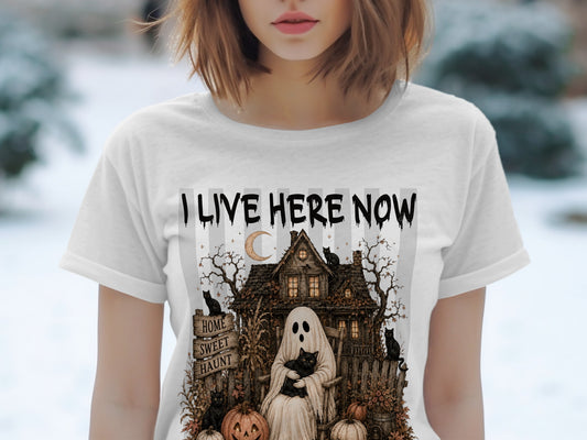 White t-shirt with "I LIVE HERE NOW" and a spooky Halloween scene with a ghost, cats, and pumpkins.