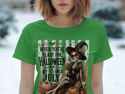 Skeleton witch with drink on shirt that reads "When You're Ready for Halloween But It's Only July."