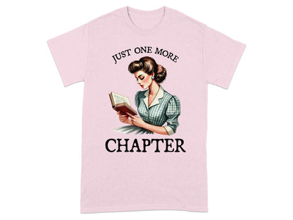 Pink t-shirt with retro illustration of woman reading, "Just one more chapter."